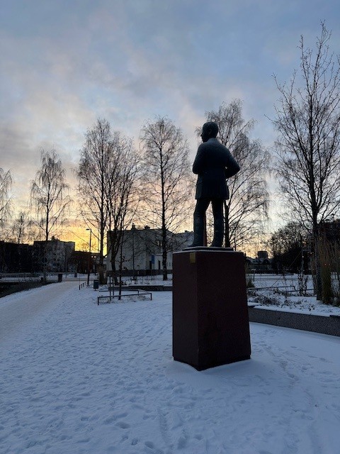 Kirjailija Teuvo Pakkalan patsas Oulun Vaaranpuistossa talvisessa maisemassa.